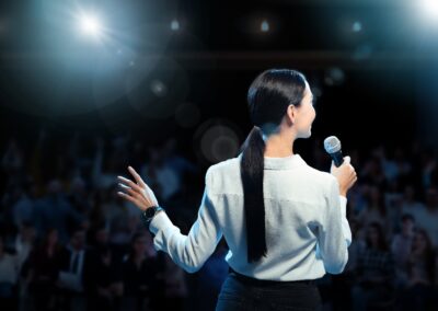 woman holding a microphone in front of an audience